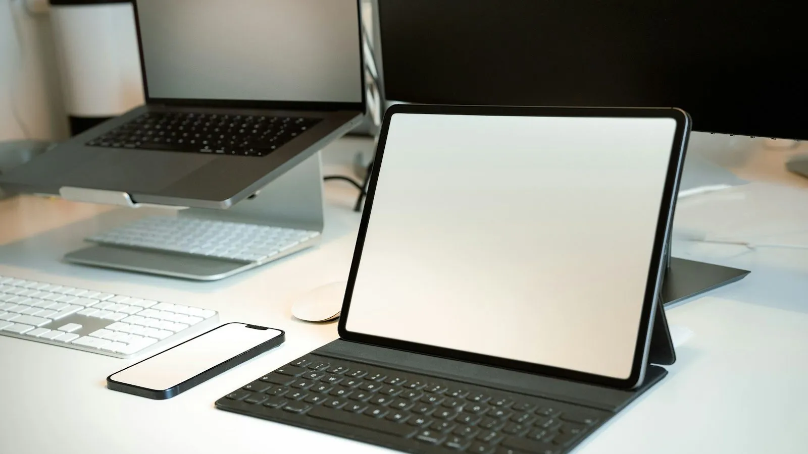 Laptop and tablet on a desk, representing in-clinic and remote ADHD testing setups