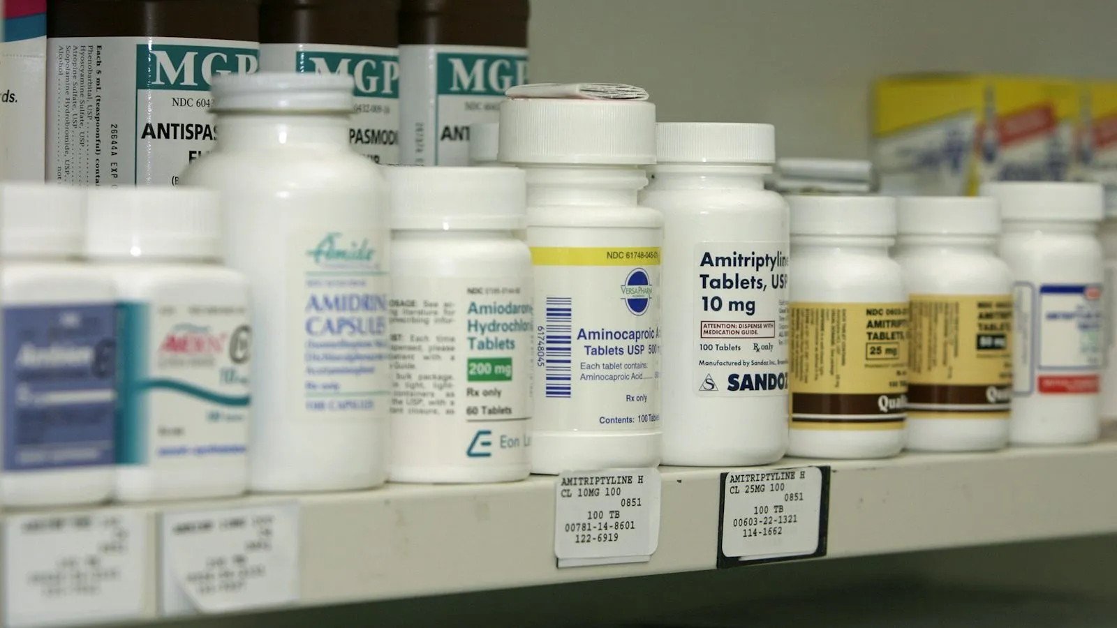 Pharmacy shelf stocked with rows of medication bottles
