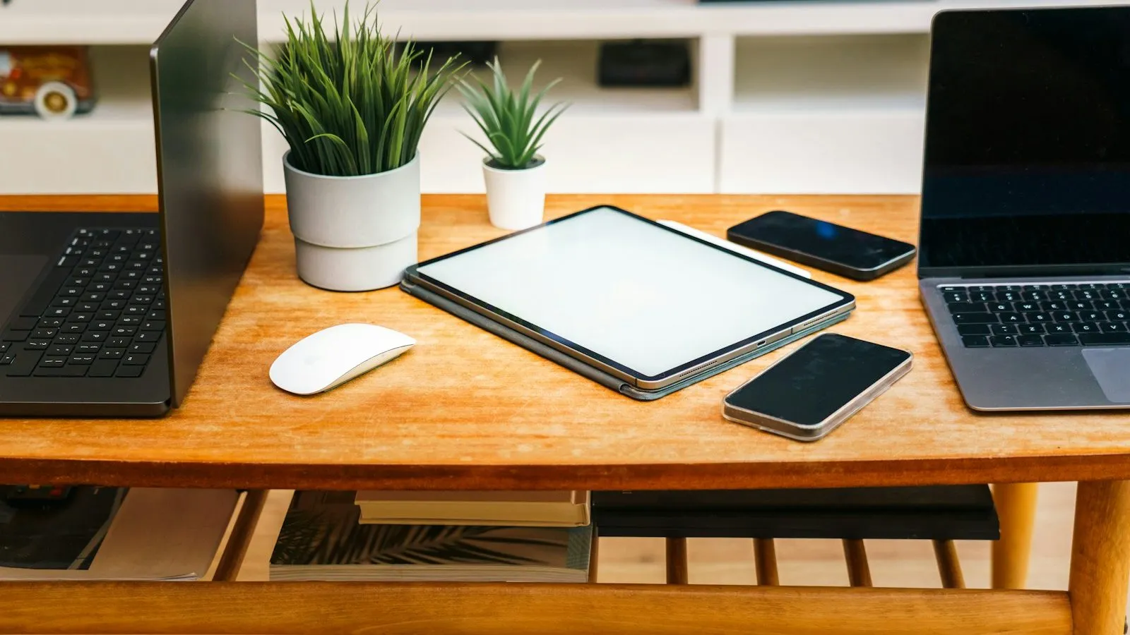 Laptops, a tablet, and smartphones on a desk, representing devices used for remote ADHD tests