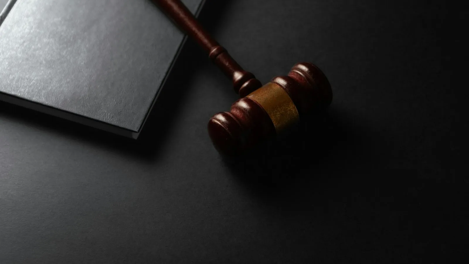Wooden gavel on a dark desk beside a closed book, representing the Done Global federal case