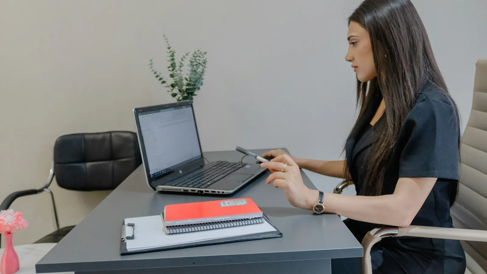 Clinician working on a laptop at a desk while comparing ADHD assessment tools