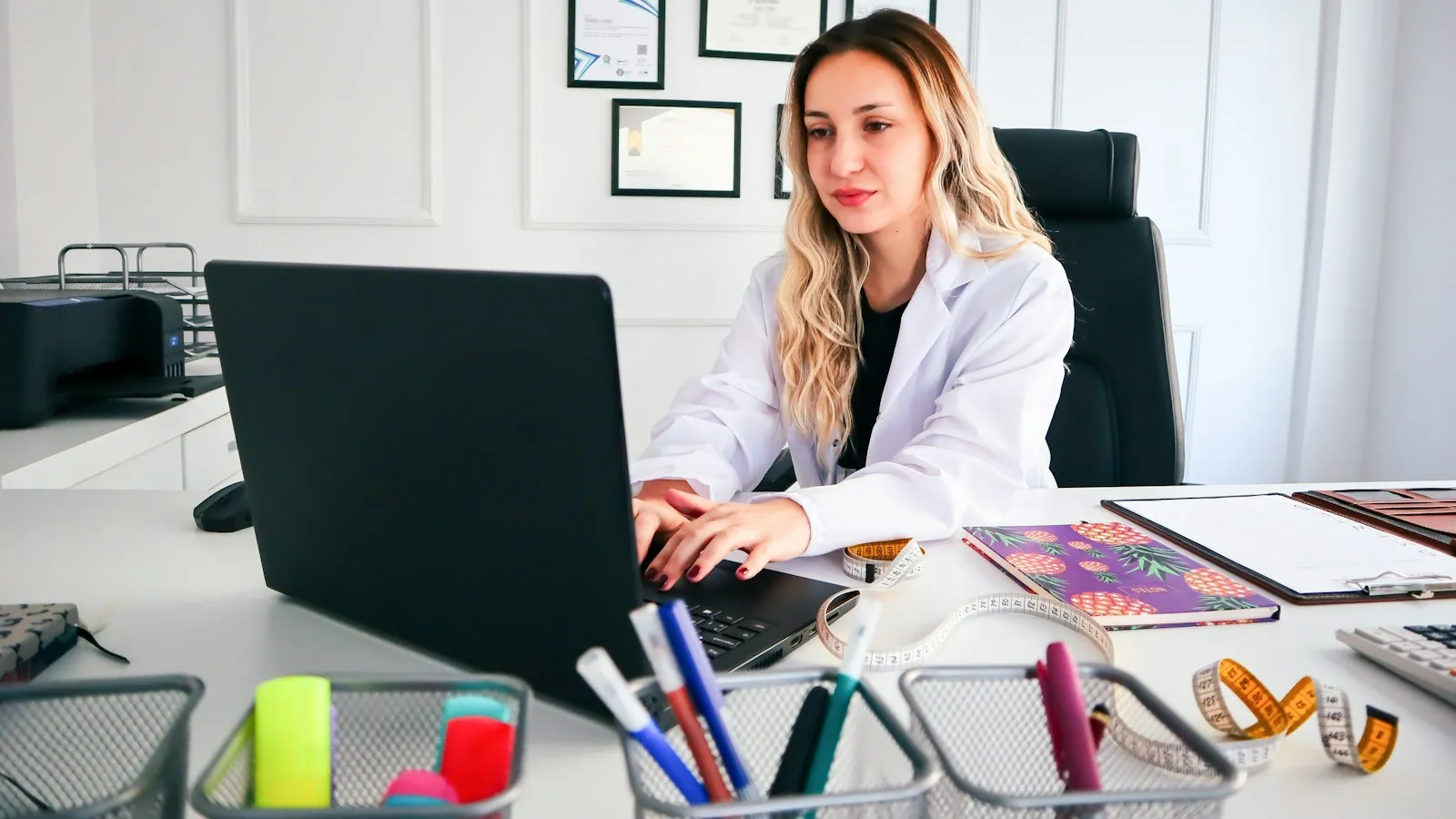 Clinician working at a laptop in her office