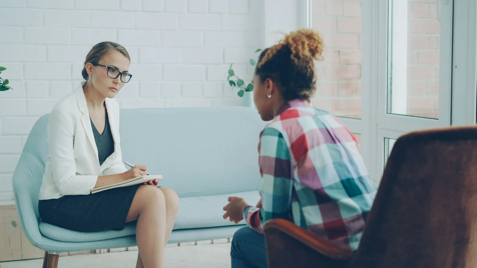 Psychologist taking notes while listening to a patient during an ADHD assessment interview